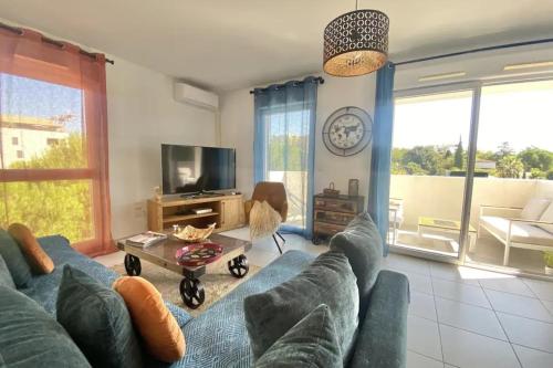 sala de estar con sofá azul y TV en Bright apartment with balcony, en Montpellier
