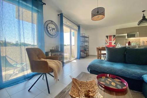 sala de estar con sofá azul y mesa en Bright apartment with balcony, en Montpellier