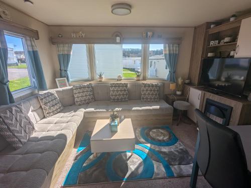 a living room with a couch and a tv at Caravan sleeps 8 at Littlesea, Weymouth in Wyke Regis
