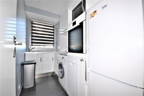 - une buanderie avec un lave-linge et une télévision dans l'établissement BEL APPARTEMENT CALME ET TRES LUMINEUX, à Antibes