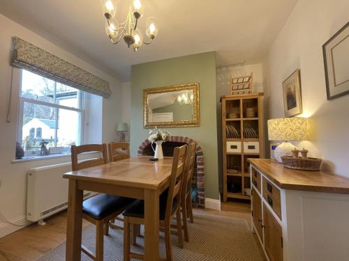 uma cozinha e sala de jantar com mesa e cadeiras em Spa Cottage em Braithwaite