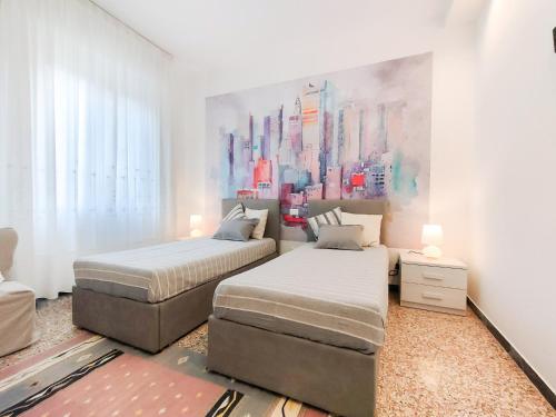 een slaapkamer met twee bedden en een schilderij aan de muur bij A casa di Ezio e Paola in La Spezia