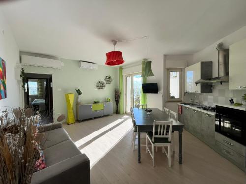 a kitchen and living room with a table and a couch at Finestra sul mare in Monfalcone