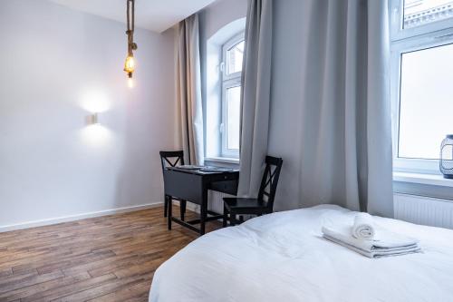 - une chambre avec un lit et un bureau dans l'établissement Janasa Comfort Studio, à Katowice