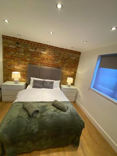 a bedroom with a large bed with two night stands at Studio apartment near Sutton, Croydon in Banstead