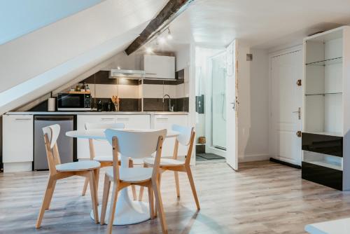 une cuisine et une salle à manger avec une table et des chaises dans l'établissement Octave 29, au Havre