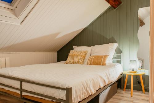 - un lit mansardé avec des draps et des oreillers blancs dans l'établissement Octave 29, au Havre