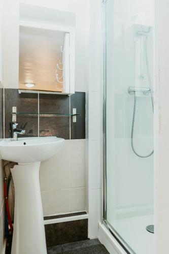une salle de bain avec un lavabo et une douche dans l'établissement Octave 29, au Havre