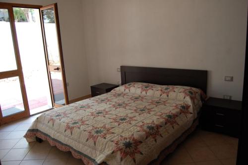 sypialnia z łóżkiem z kołdrą w obiekcie Appartamento di nuova costruzione con veranda vista mare a Maladroxia C66 w mieście Maladroscia