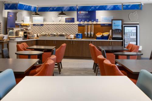 a restaurant with tables and chairs and a counter at Holiday Inn Express Hotel & Suites Brattleboro by IHG in Brattleboro