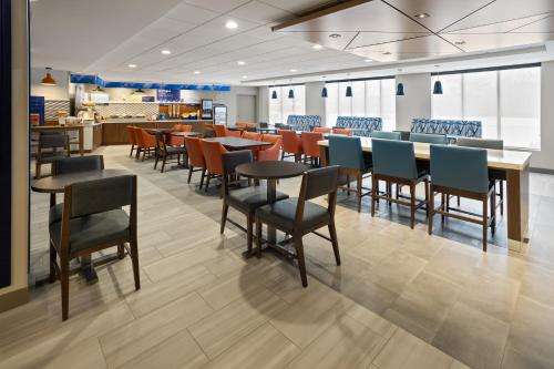 uma sala de jantar com mesas e cadeiras num restaurante em Holiday Inn Express Hotel & Suites Brattleboro, an IHG Hotel em Brattleboro