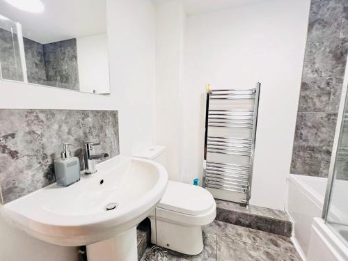 een witte badkamer met een toilet en een wastafel bij Stylish Cambridge Apartment with Garden in Cambridge
