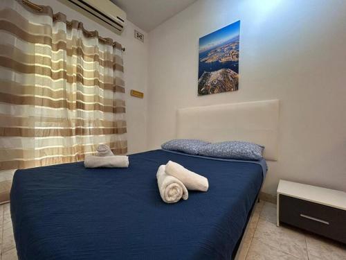 a bedroom with a blue bed with towels on it at Seaview Serenity 3-Bedroom Apt view over Valletta Harbour in Sliema