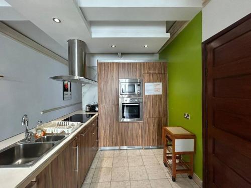 a kitchen with green walls and a sink and a stove at Seaview Serenity 3-Bedroom Apt view over Valletta Harbour in Sliema