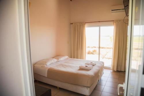 a bedroom with a bed with towels on it at La Posta Hotel de Campo in Tres Lomas