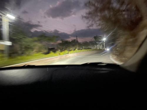 a view from a car windshield of a street at night at Vangau in Esquipulas
