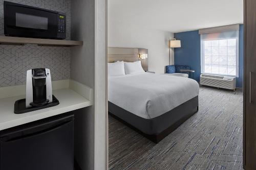 a hotel room with a bed and a tv at Holiday Inn Express Hotel & Suites Brattleboro by IHG in Brattleboro