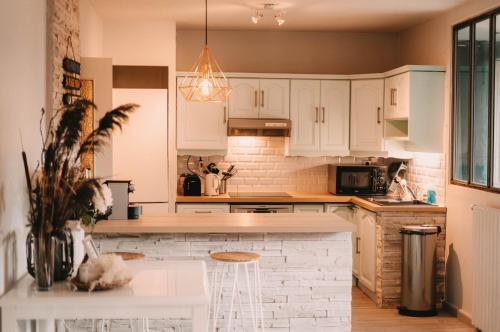 une cuisine avec des placards blancs et un comptoir blanc dans l'établissement Charmant 2 pièces avec terrasse - Proche Gare et Centre Ville, à Besançon