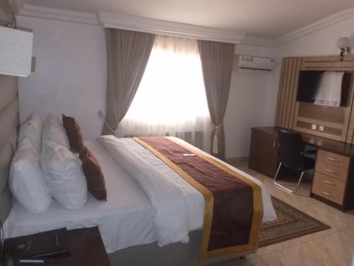 a hotel room with a bed with a window at Immaculate Diamond Hotel & Apartments in Abuja