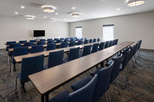 a conference room with tables and chairs and a screen at Holiday Inn Express Hotel & Suites Brattleboro by IHG in Brattleboro