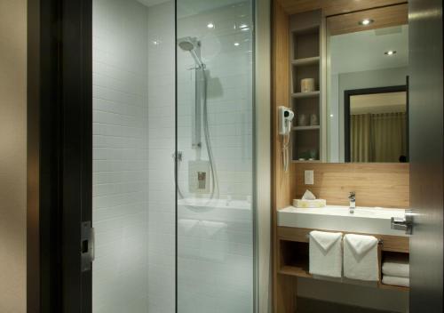 uma casa de banho com um chuveiro e um lavatório. em Motel Idéal Ste-Rose em Laval