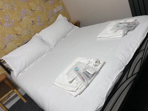 a bed with white towels and a pair of scissors on it at Woolaway 2 in Taunton