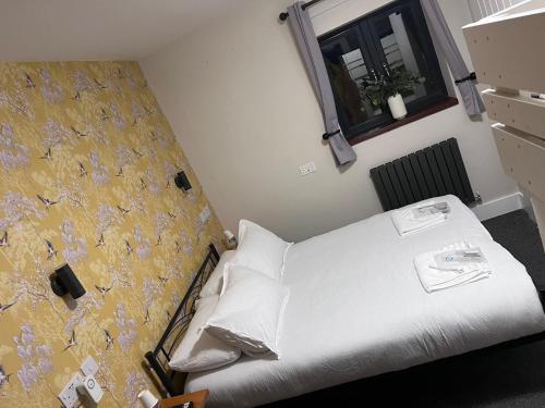 een slaapkamer met een wit bed en een raam bij Woolaway 2 in Taunton