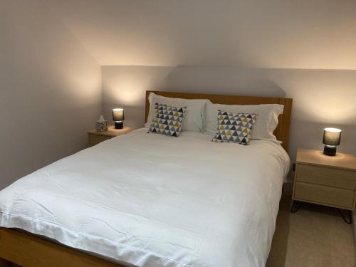 a bedroom with a large white bed with two night stands at Downs Cottage in Bristol