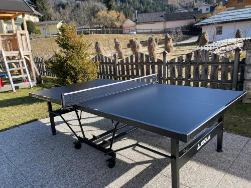 a ping pong table in a yard with a fence at Chalet Mama in Pruggern