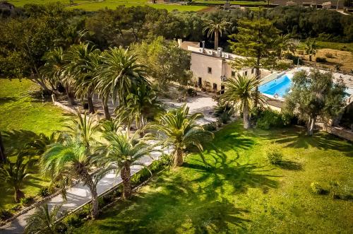 an aerial view of a resort with a pool and palm trees at Finca Hotel Rural Predio Son Serra in Can Picafort