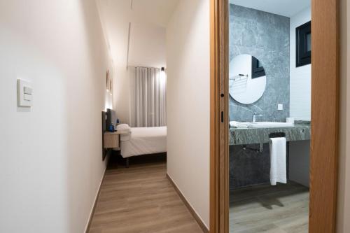 a room with a bathroom with a sink and a mirror at Hotel A Mares in Celorio