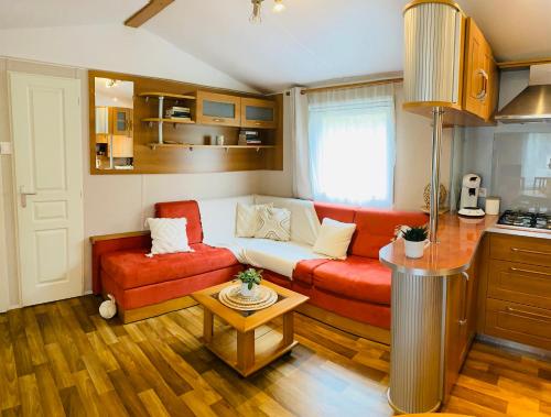 Mobil Home proche de la mer في Saint-Martin-Plage: غرفة معيشة مع أريكة وطاولة