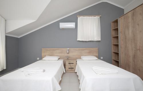 two beds in a room with white walls at Villa Raya3 in Fethiye
