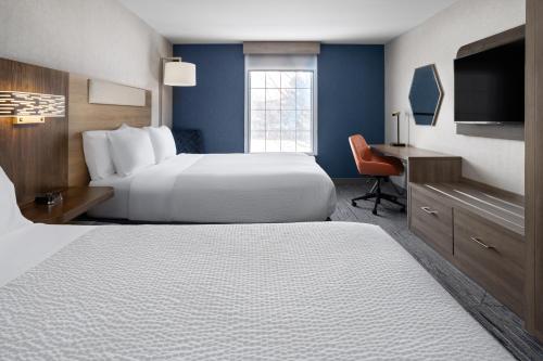 a hotel room with a bed and a desk at Holiday Inn Express Hotel & Suites Brattleboro by IHG in Brattleboro