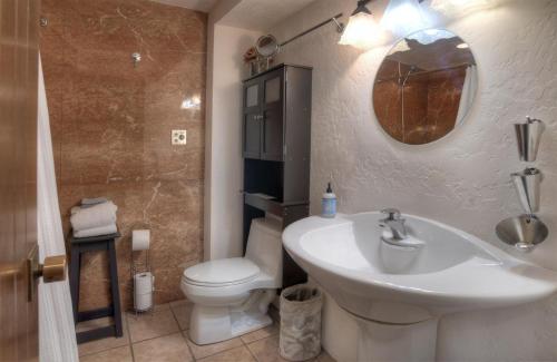 W łazience znajduje się umywalka, toaleta i lustro. w obiekcie Tamarron Lodge Suite 502 w mieście Durango