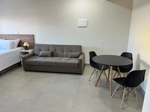 a living room with a couch and a table and chairs at Condomínio Kaimã in Matinhos