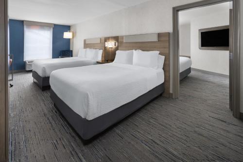 a hotel room with two beds and a television at Holiday Inn Express Hotel & Suites Brattleboro by IHG in Brattleboro