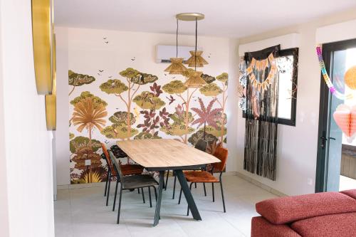 a dining room with a table and chairs and a wall at ENTRE TERRE ET MER in Desvres