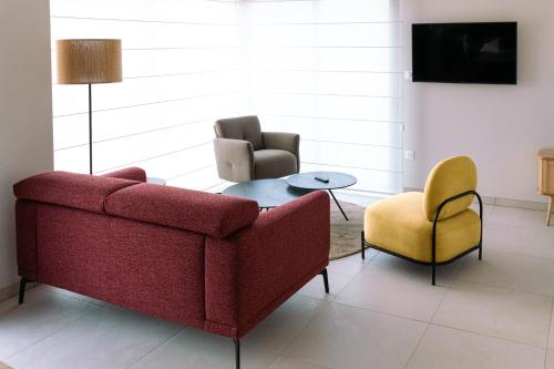 uma sala de estar com um sofá, uma mesa e cadeiras em ENTRE TERRE ET MER em Desvres