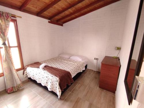 Hermoso apartamento en Curití في كوريتي: غرفة نوم بسرير وطاولة في غرفة