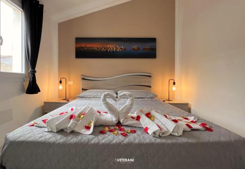 uma cama com dois cisnes feitos de toalhas em Veterani Holidays Cefalù em Cefalù