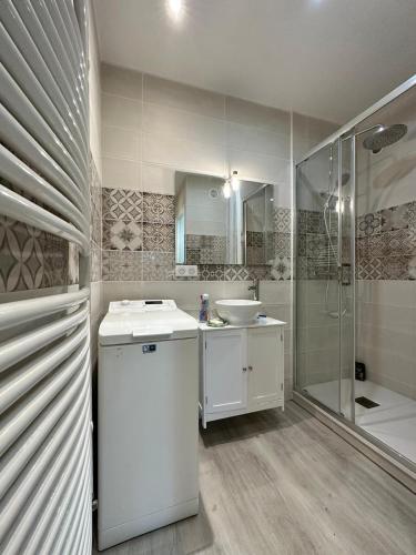 une salle de bain blanche avec un lavabo et une douche dans l'établissement Charmant 2 pièces avec terrasse - Proche Gare et Centre Ville, à Besançon