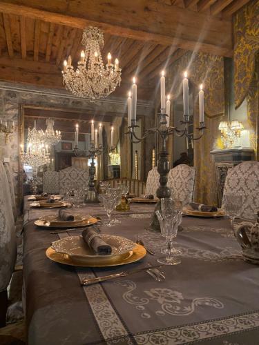a dining room with a long table and chandelier at Château de Morgenex in Vallières