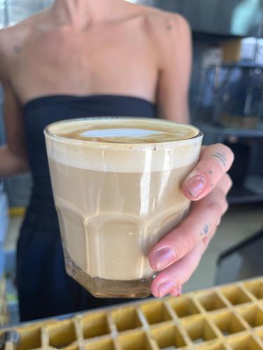 a woman is holding a cup of coffee at Pupa House - Capsule Hotel - Adults Only in Tamarindo