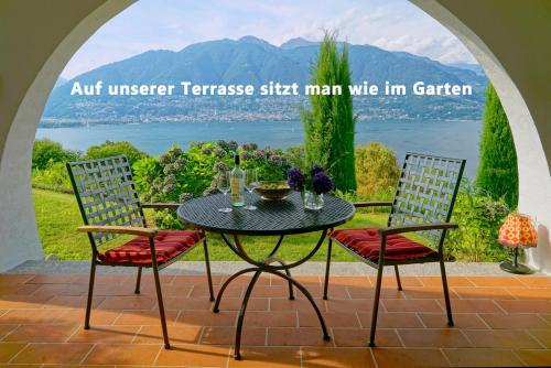 una mesa al aire libre con 2 sillas frente a una ventana en TOP-Ferienwohnung im Landhausstil mit Panoramablick & Pool, en Vira