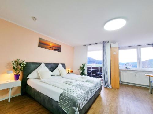 a bedroom with a large bed and a large window at FeWo mit Pool in Baiersbronn in Baiersbronn