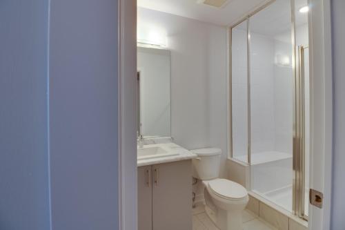 a white bathroom with a toilet and a sink at Brand new townhouse, 30 minutes to Downtown in Toronto