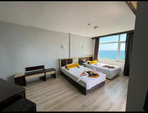 een grote kamer met 2 bedden en een tafel bij Bay Luna Beach hotel in Alanya