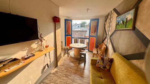 - un salon avec une télévision, un canapé et une table dans l'établissement La Marteja, à Salento