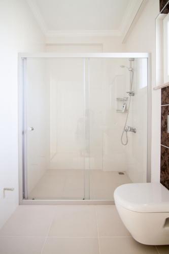 a white bathroom with a shower and a toilet at Villa Kaylem in Dalyan
